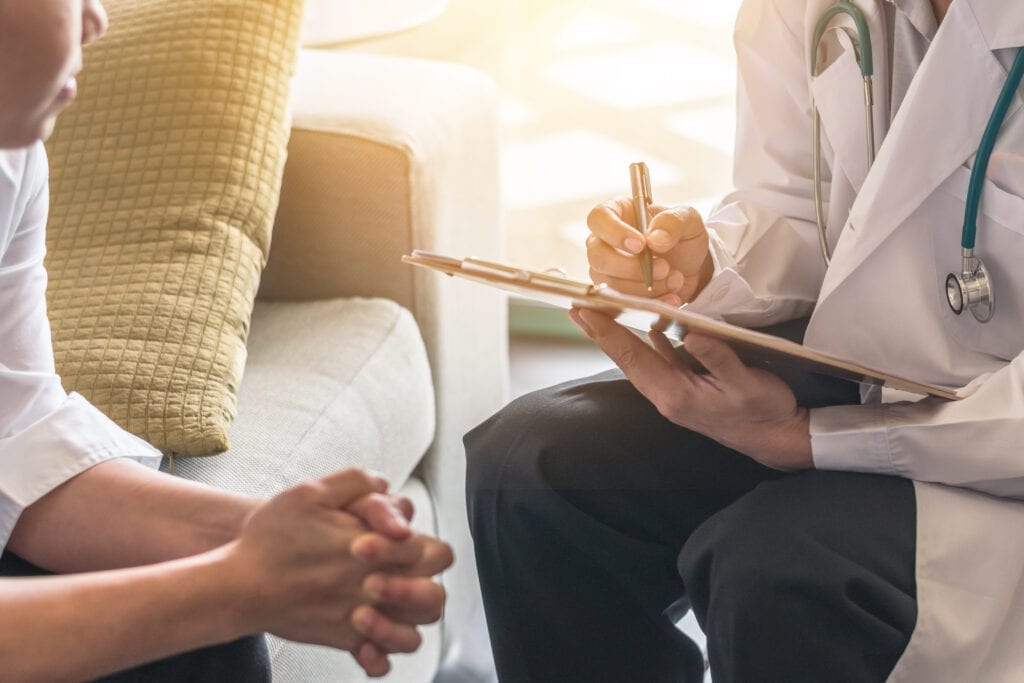 Woman patient having consultation with telemedica telehealth telemedicine doctor psychiatrist examining and writing nexus letters for veterans health in medical gynecological clinic or hospital mental health service center